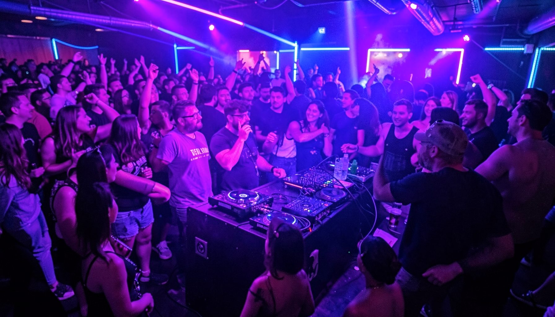 A high-energy pre-game party scene with neon accents, a DJ booth, and a buzzing crowd in purple and blue light
