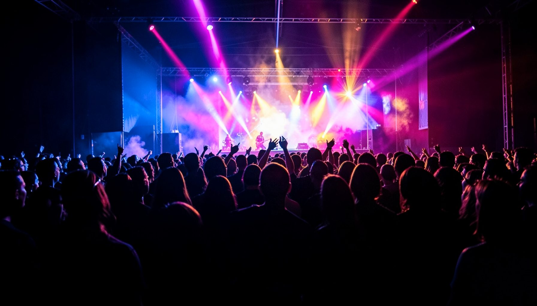 A vibrant concert crowd silhouetted against colorful stage lights, deep blues and magentas with warm gold highlights